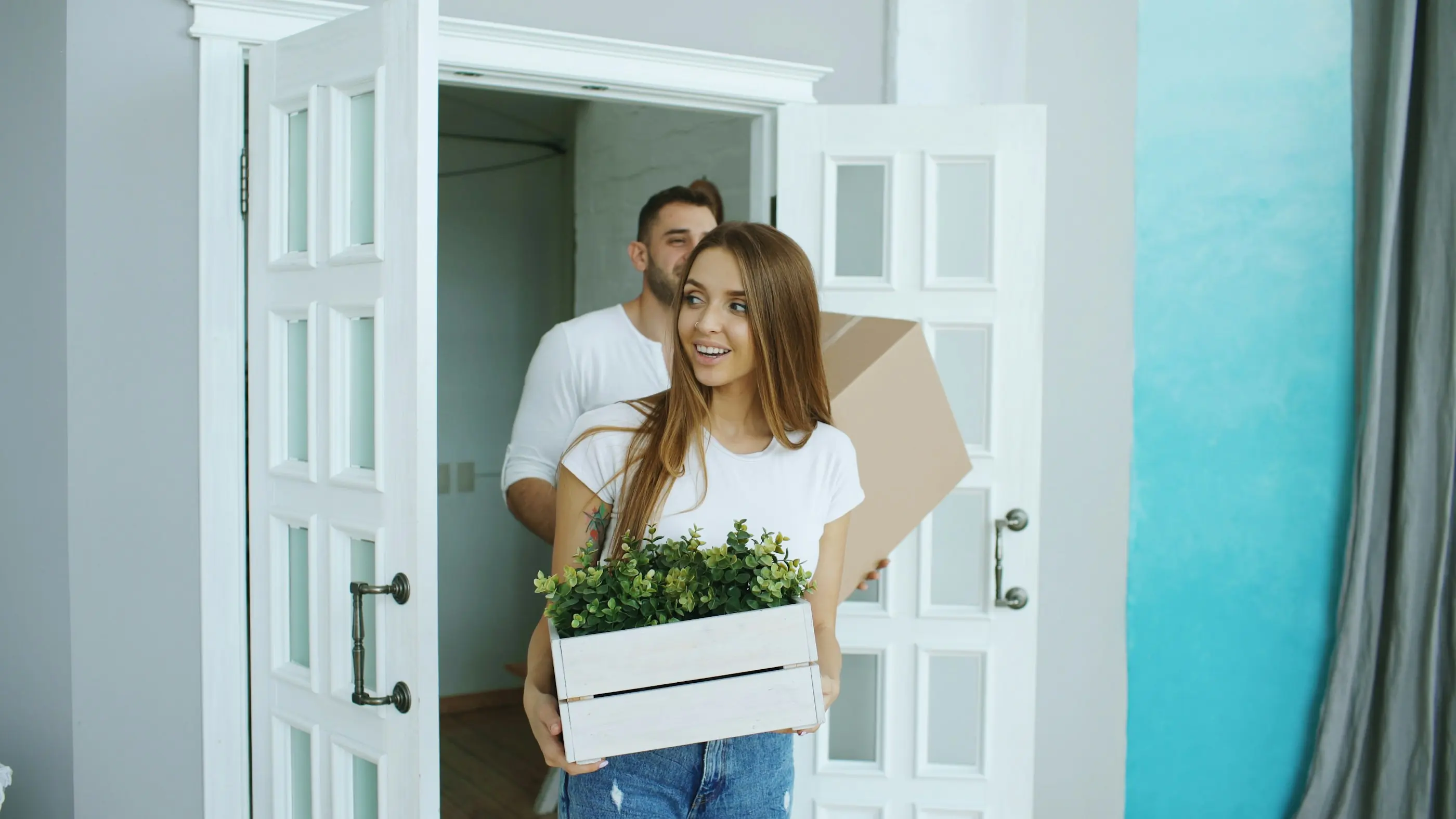 Paar trägt Umzugskartons in das neue Zuhause