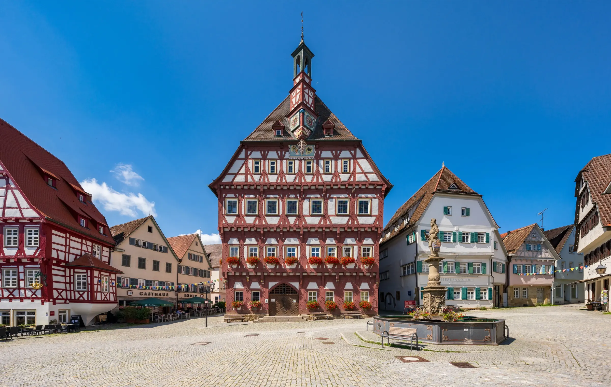 Marktplatz in Markgröningen mit dem Fachwerkrathaus von 1440/41 und dem historischen Marktbrunnen an einem Sommertag